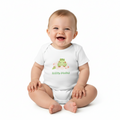 Smiling baby sitting in Sleepy-saurus onesie