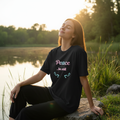 Woman wearing boyfriend-style Peace be still t-shirt in peaceful setting